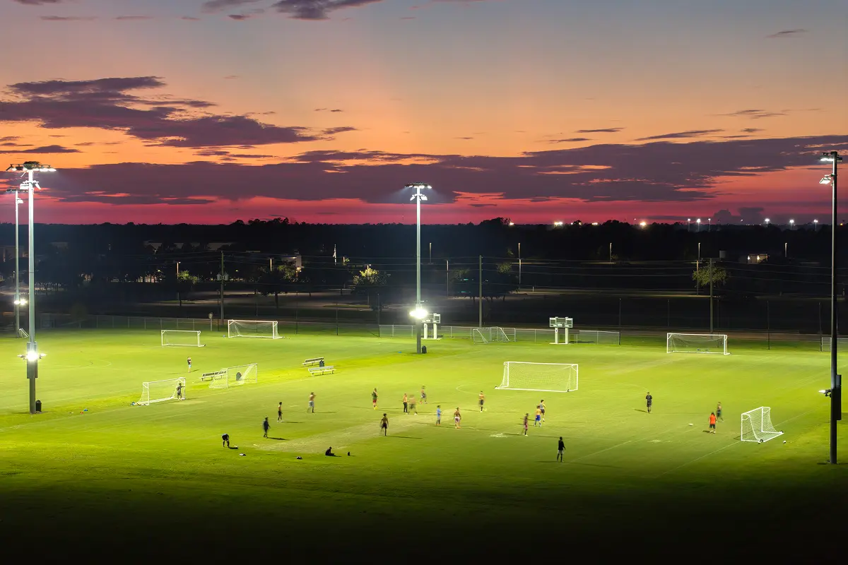 Soccer practice at sunset under lights.